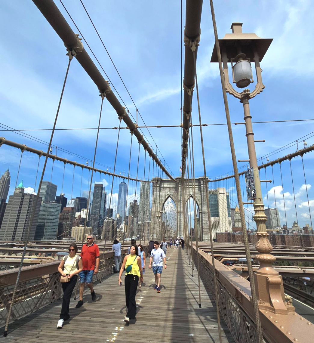 Walkers on the Brooklyn Bridge promenade beneath the cables